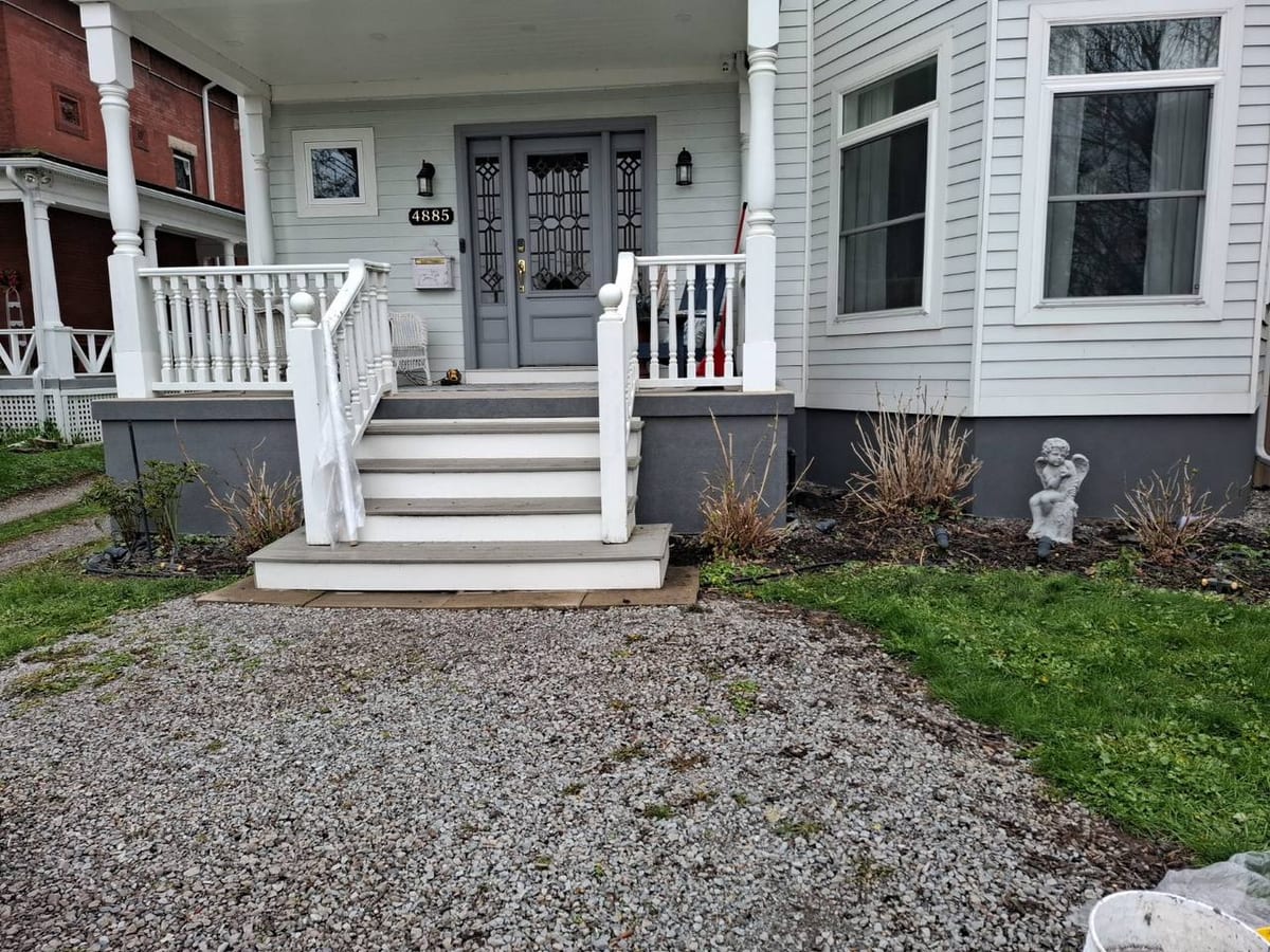Exterior porch repair with white railing and restored entry details