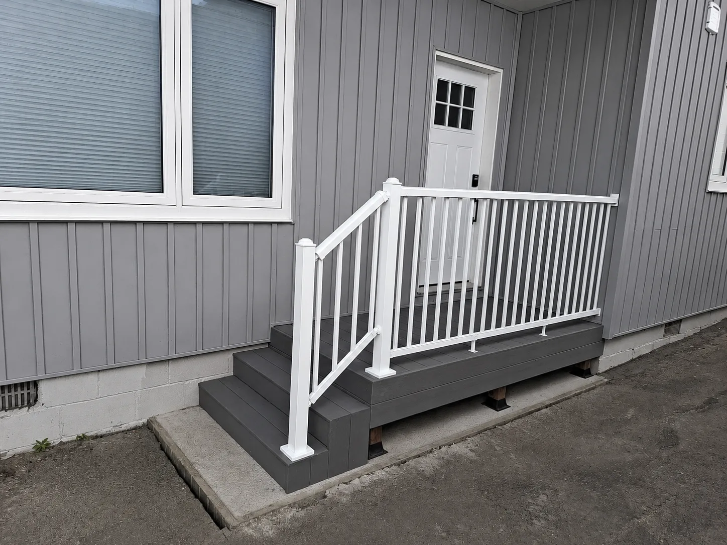 Side deck build with grey decking and white railing — finished railing wide view