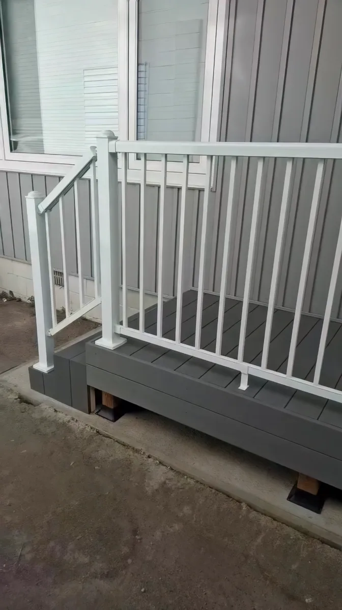 Side deck build with grey decking and white railing — finished side railing view