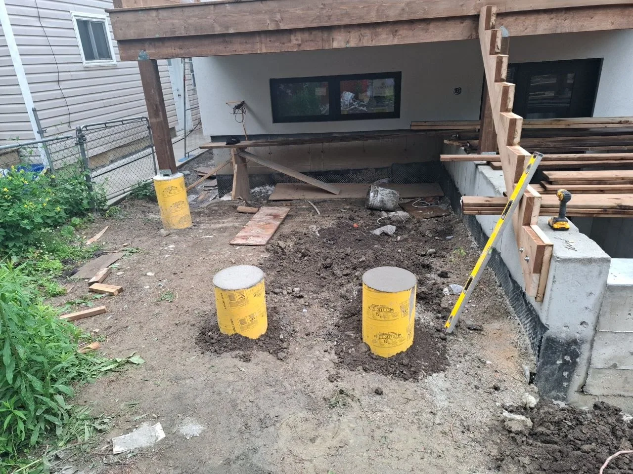 Modern Toronto townhome deck build with natural wood decking and railing — concrete piers poured