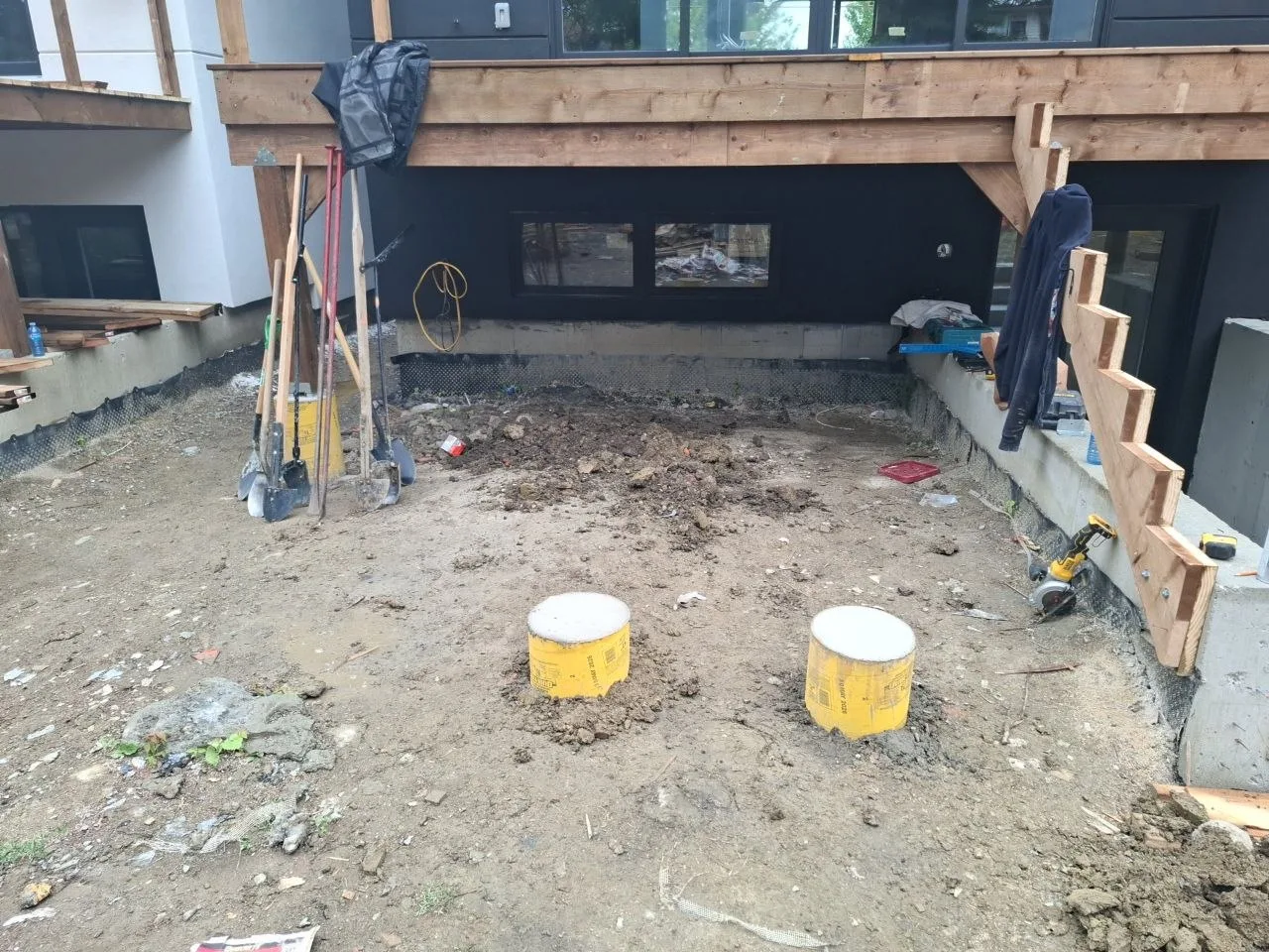 Modern Toronto townhome deck build with natural wood decking and railing — concrete piers set