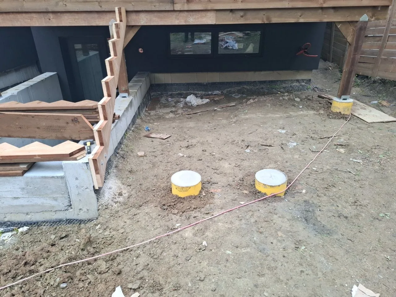 Modern Toronto townhome deck build with natural wood decking and railing — piers and stair framing