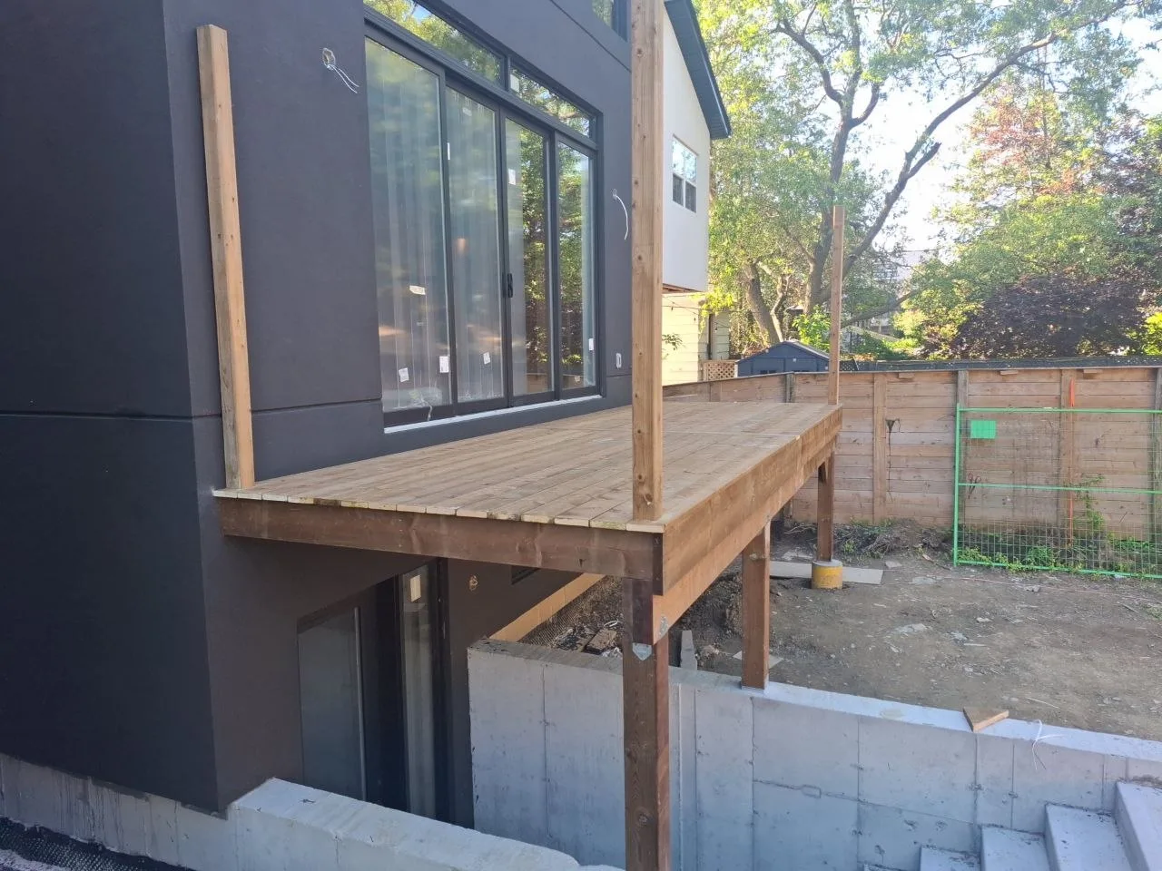 Modern Toronto townhome deck build with natural wood decking and railing — decking down with railing posts