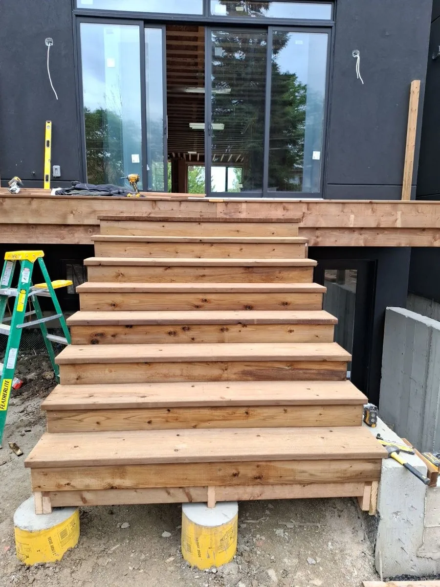 Modern Toronto townhome deck build with natural wood decking and railing — finished deck stairs