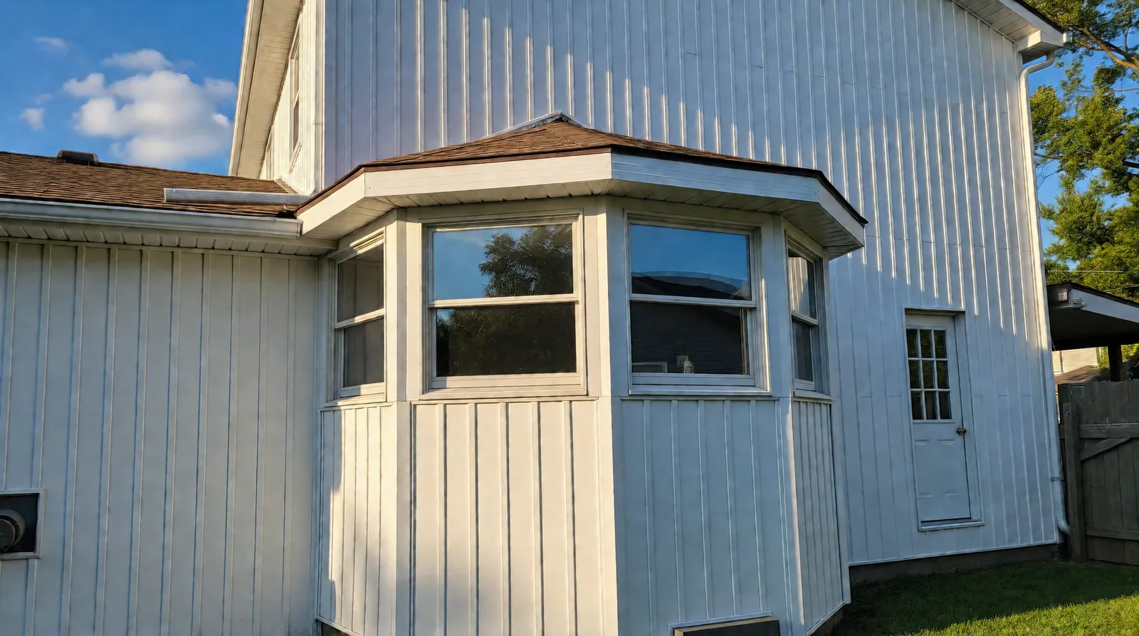 Bay window and rear wall finished in white vertical siding